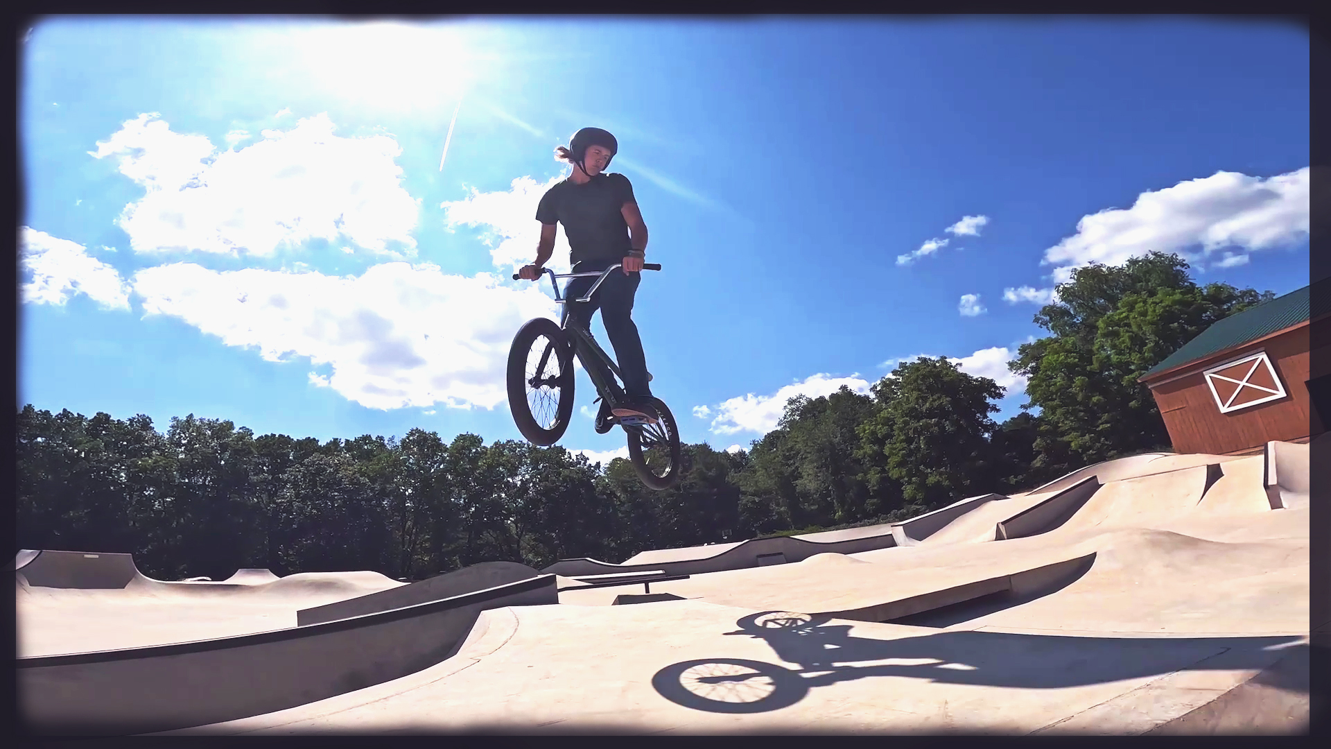 BMXer jumps a hump in a concrete park